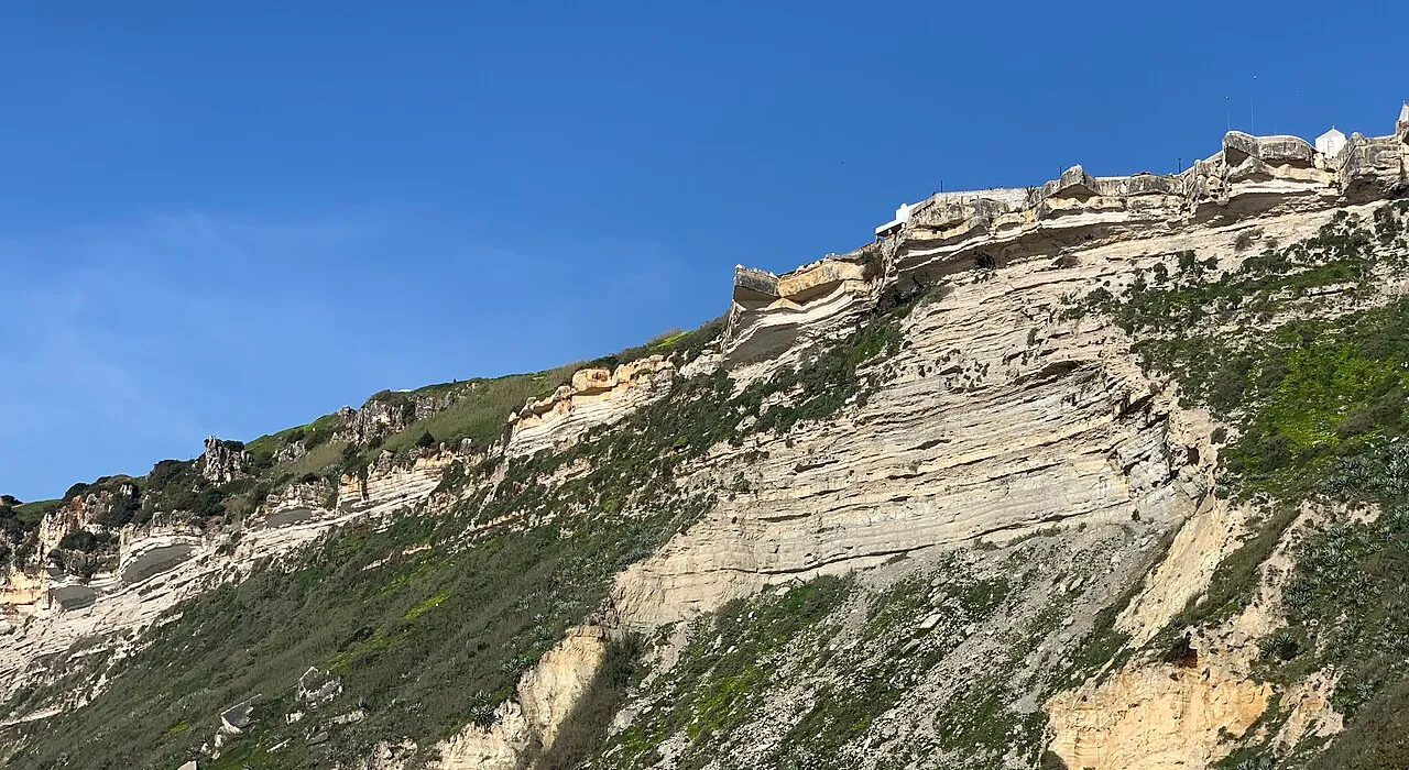 Falésia junto à praia da Nazaré, com o miradouro do Sítio ao fundo