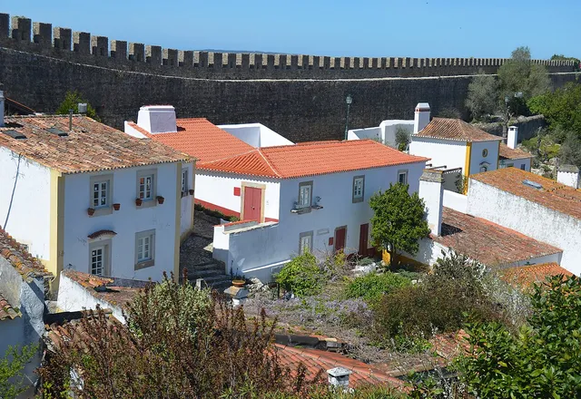 Telhados vermelhos e casas brancas de Óbidos vistos de dentro da muralha do castelo