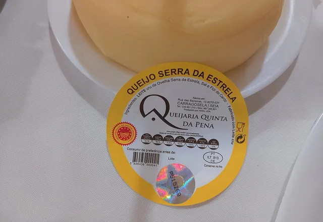 A whole wheel of Queijo Serra da Estrela DOP cheese, with the dairy's label